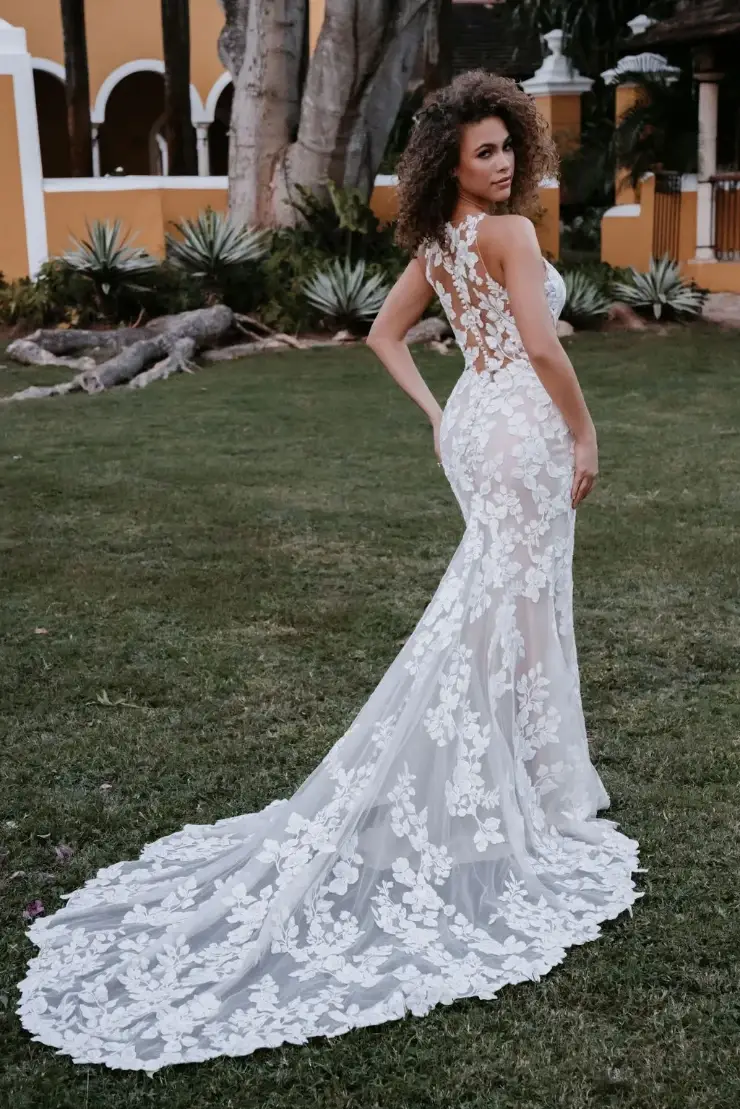model is wearing a sleeveless fit and flare lace wedding dress